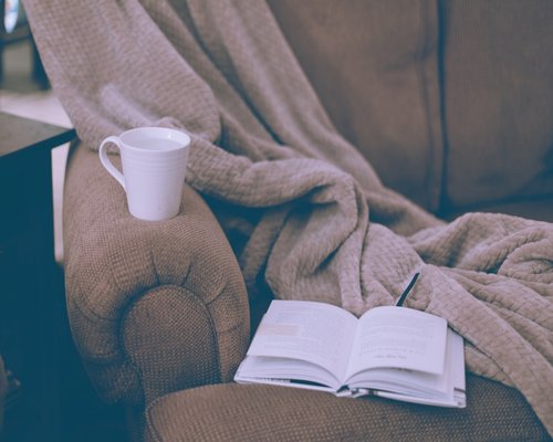Person relaxing calmly at home reading a book